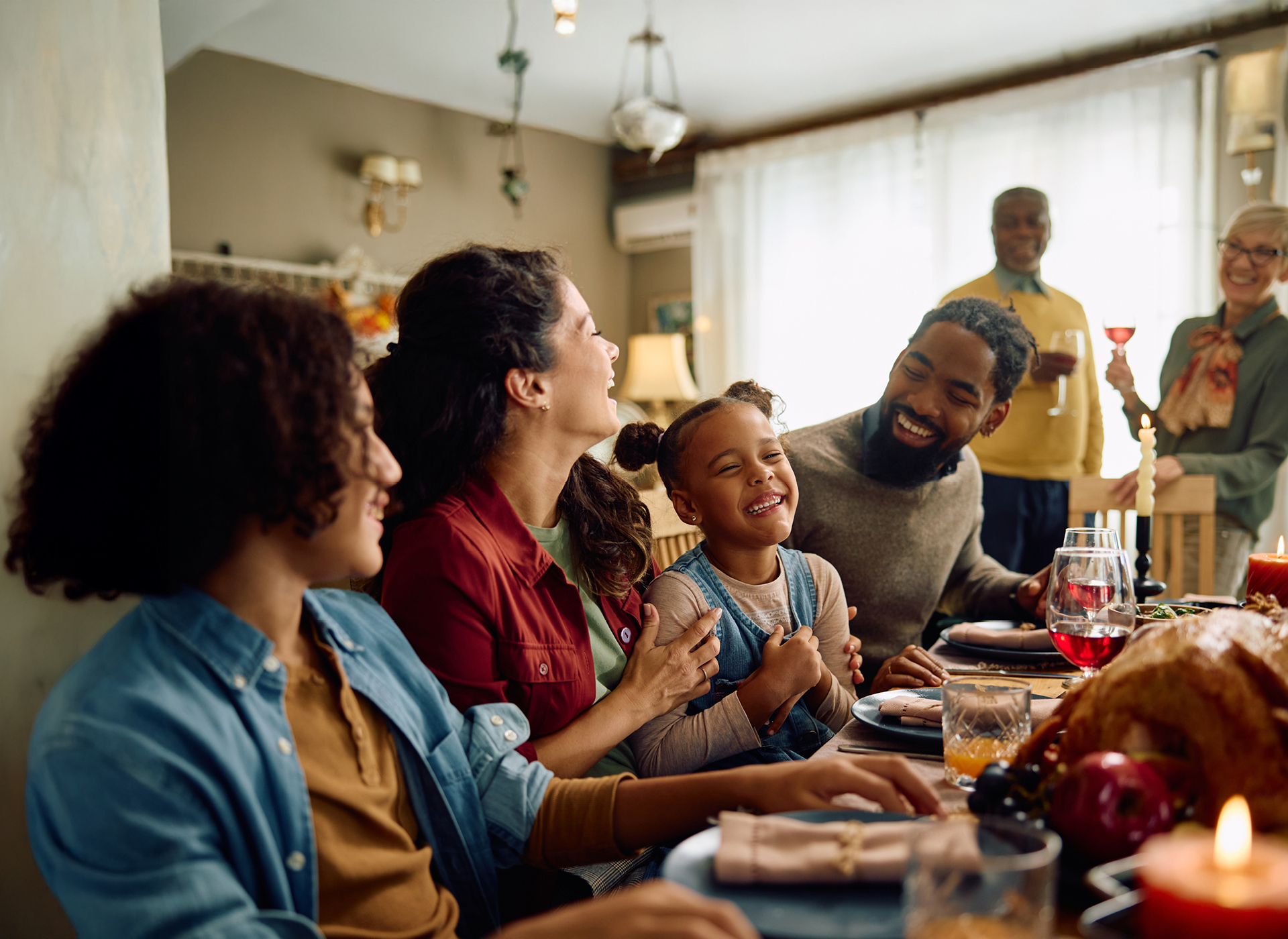 a family sits around a dinner table smiling