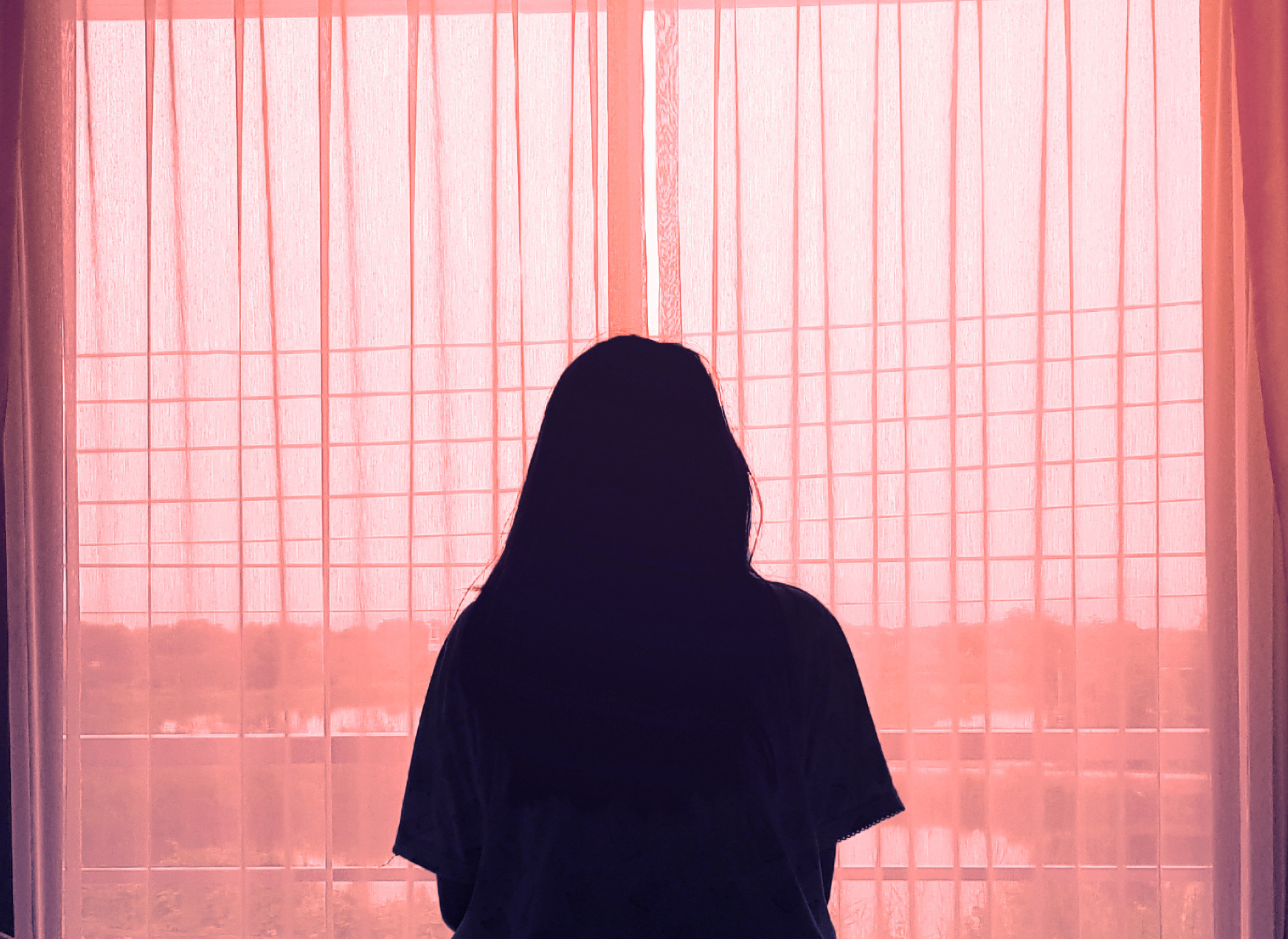 Silhouette of woman in front of a window