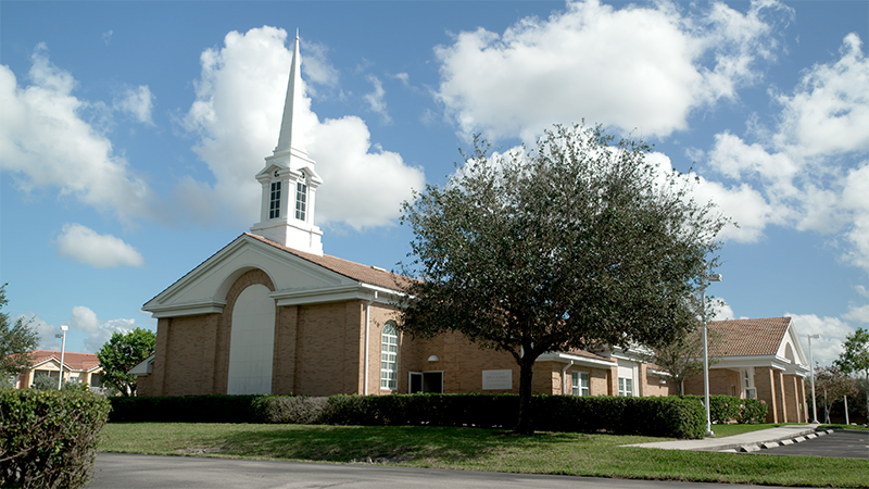 tan brick church with white steeple