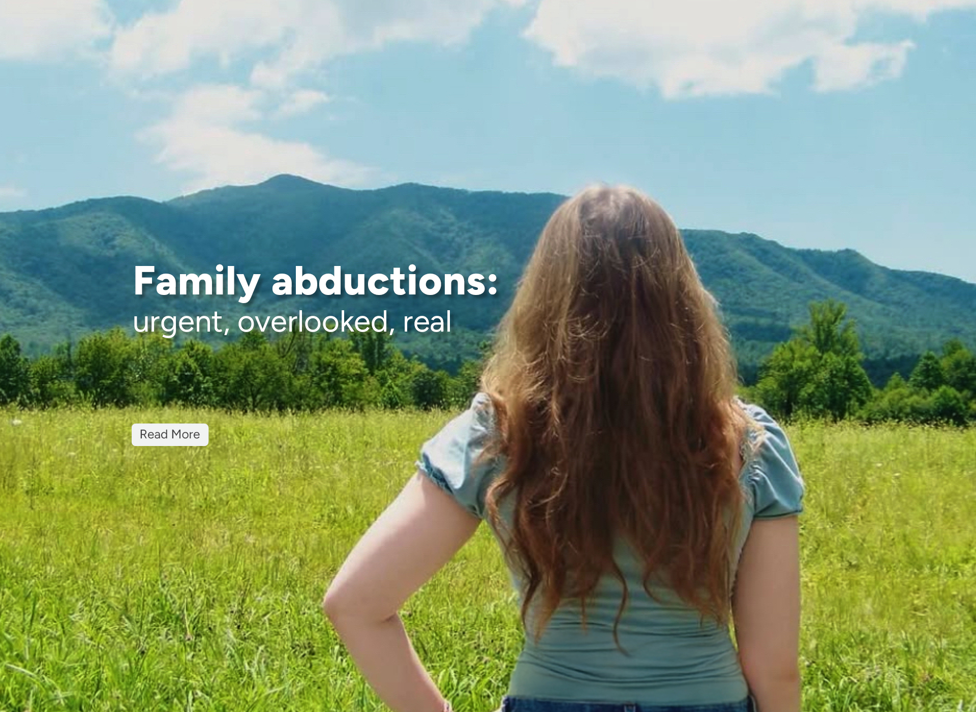 teen girl with long hair looks out at mountain landscape